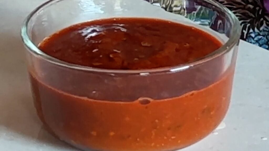 Photo shows a bowl of a bright red salsa