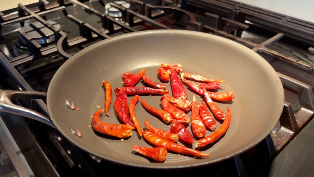 Photo shows arbol chiles in a frying pan