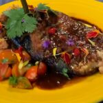 Photo shows a plate with stuffed chile, rice and cherry tomatoes.
