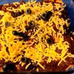 Photo shows a pan of four enchiladas ready to bake