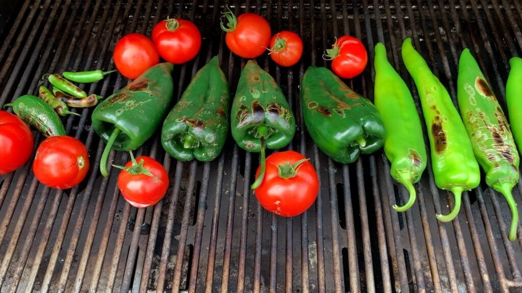 Photo shows chiles and tomatoes on the grill.