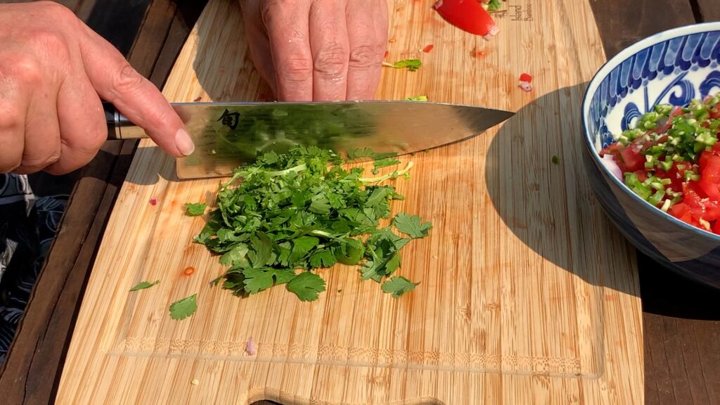 Photo shows cilantro being chopped