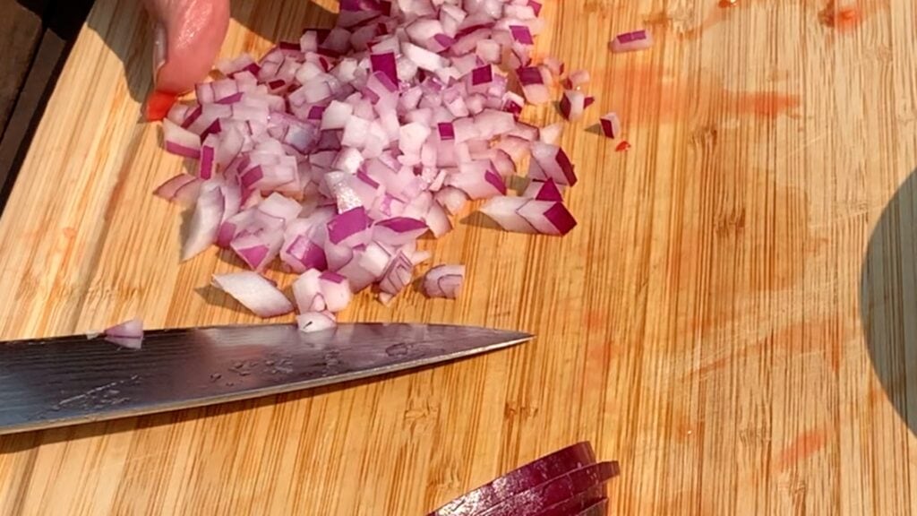 Photo shows an onion being diced
