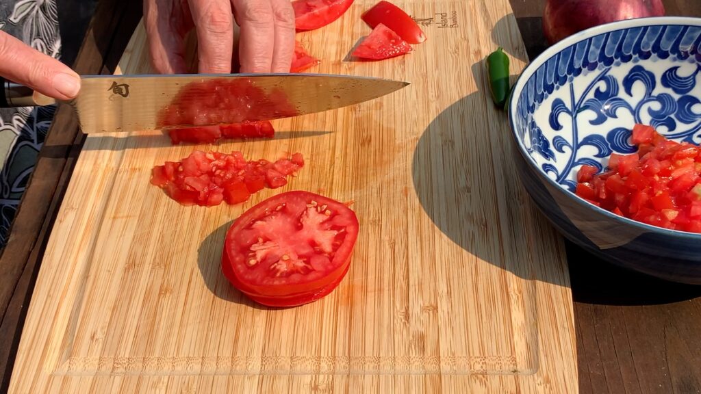 Photo shows a tomato being diced