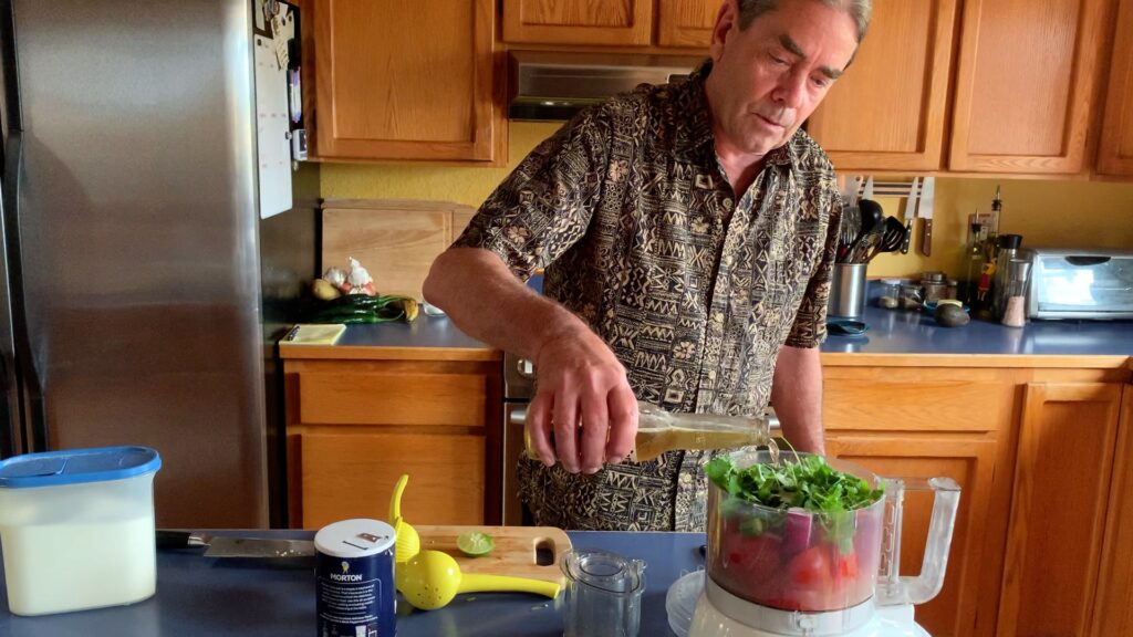 Photo shows Mr Cook adding beer to all the ingredients in the food processor