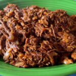 Photo shows a platter of Tinga, shredded chicken with a chipotle sauce
