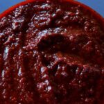 Photo shows a bowl of dark red chile sauce.