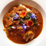 Photo shows a bowl of butter chicken