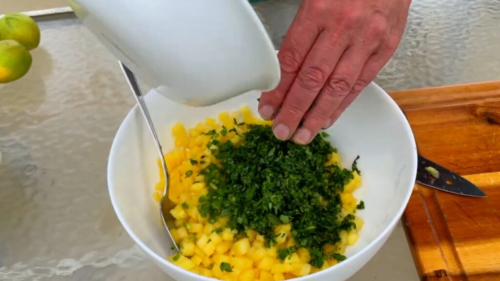 Photo shows the serrano and cilantro added to the pineapple