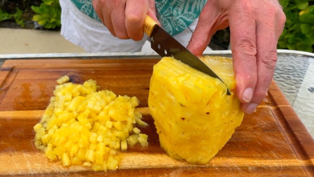 Photo shows making parallel cuts down into the pineapple