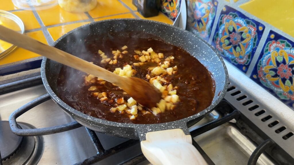 Photo shows diced pineapple added to the molé