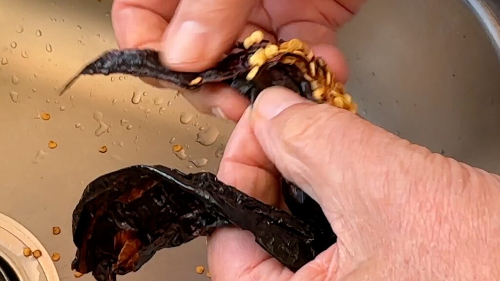 Photo shows removing the seeds from the chiles
