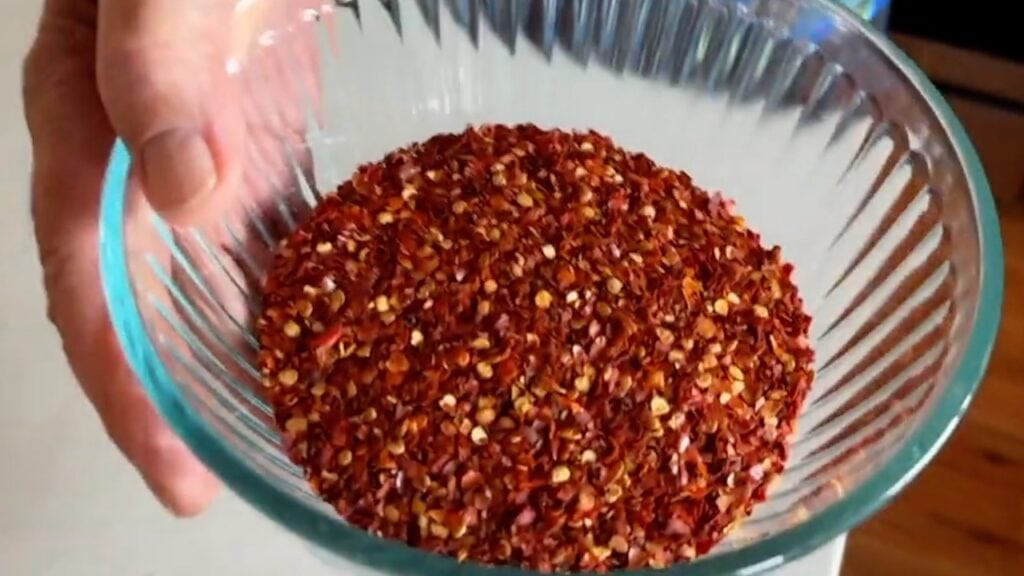 Photo shows chile flakes in a glass bowl