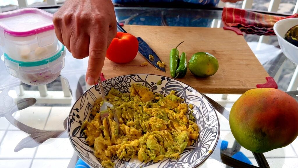 Photo shows mashing the avocado with a fork