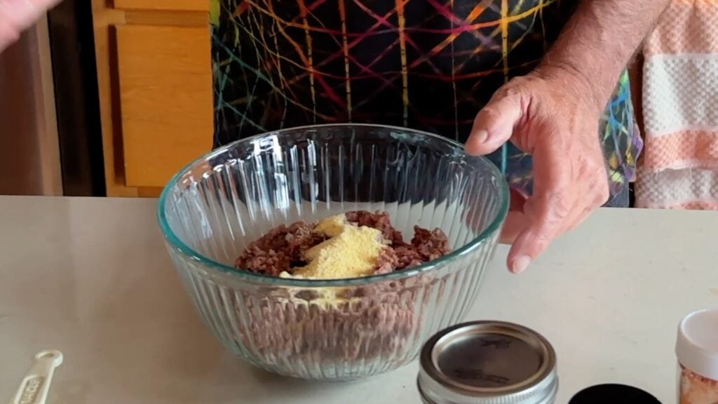 Put the ground beef and cornmeal in a mixing bowl