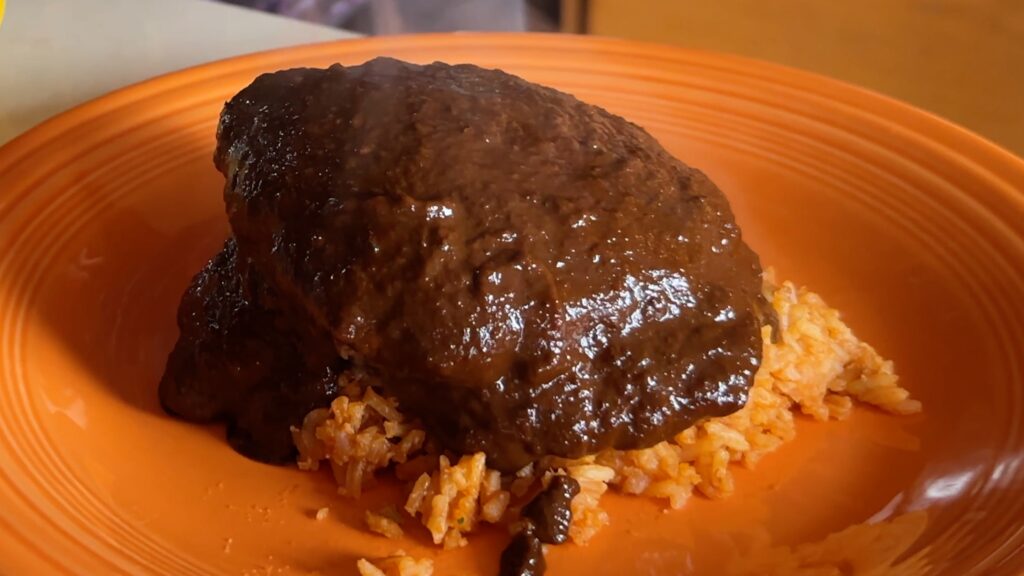 Photo shows molé on top of the rice and hamburger patty