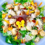 Caesar Salad garnished with edible flowers