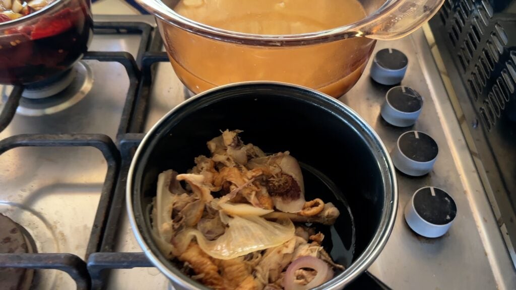 Photo shows the strained broth and the bones and onion