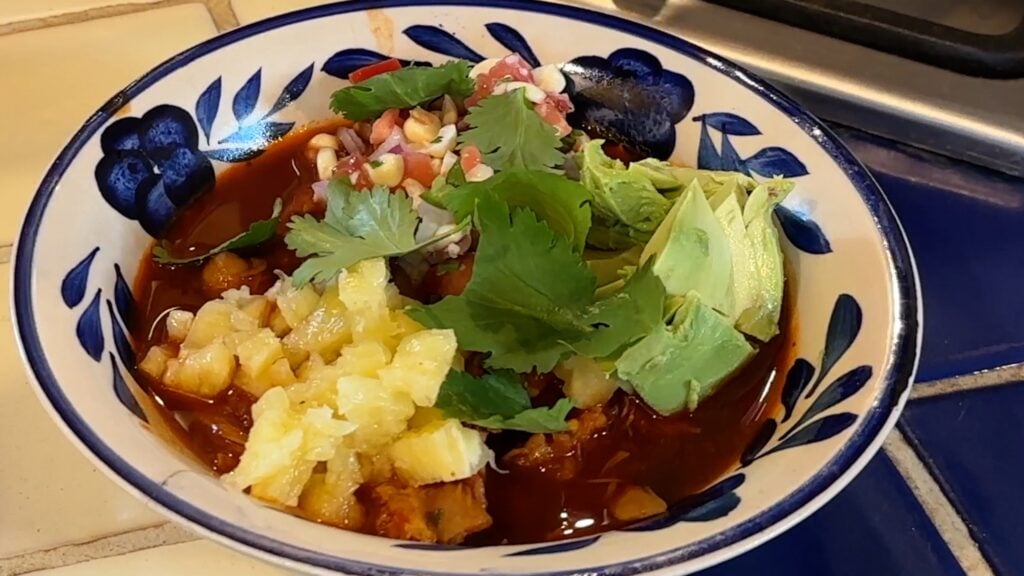 Photo shows cilantro garnish on the bowl of pollo poxole rojo