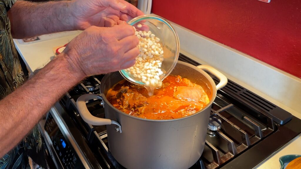 Photo shows hominy being added to the pot