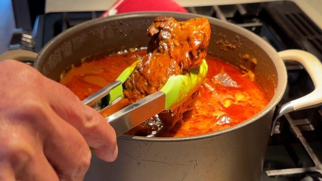 Photo shows the beef being removed from the pot