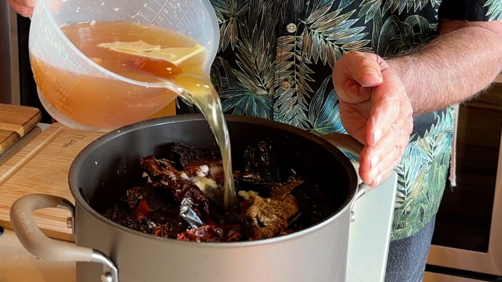 Photo shows the beef broth and water being added to the pot