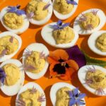 Photo shows the deviled eggs all done and garnished with edible flowers