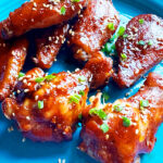 Photo shows Sticky Asian Chicken Wings on a blue plate