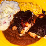 Photo shows molé almondrado on a lacquered chicken dish