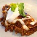 Photo shows one enchilada served on a plate